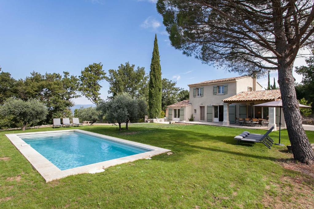 a yard with a swimming pool and a house at Les Amandiers in Bonnieux