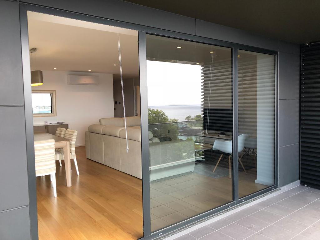 un salon avec des portes coulissantes en verre et une salle à manger dans l'établissement Astro Vista Madeira Apartments, à Funchal