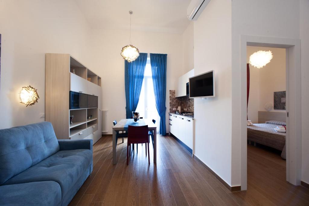 un soggiorno con divano blu e tavolo di Italia Apartment OrtoBotanic Garden a Napoli