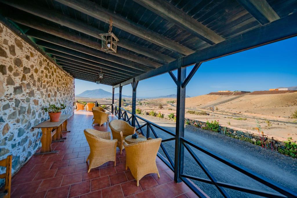 a patio with chairs and tables and a view of the desert at Hotel Rural Huerto Viejo in Tesejerague
