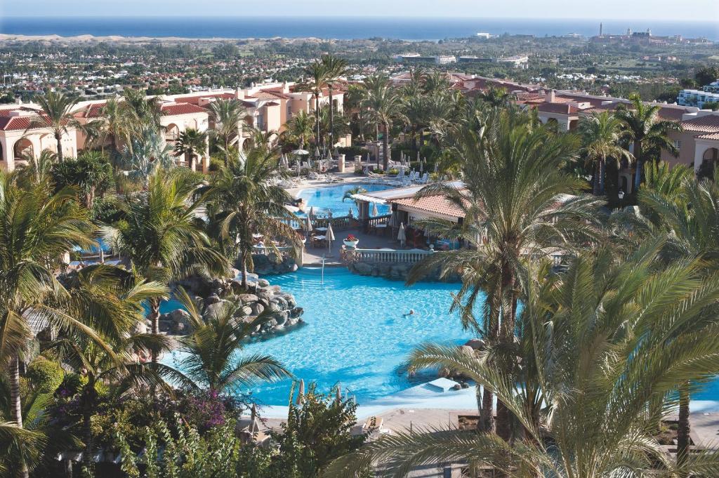 una vista aérea de una piscina del complejo con palmeras en Palm Oasis Maspalomas, en Maspalomas