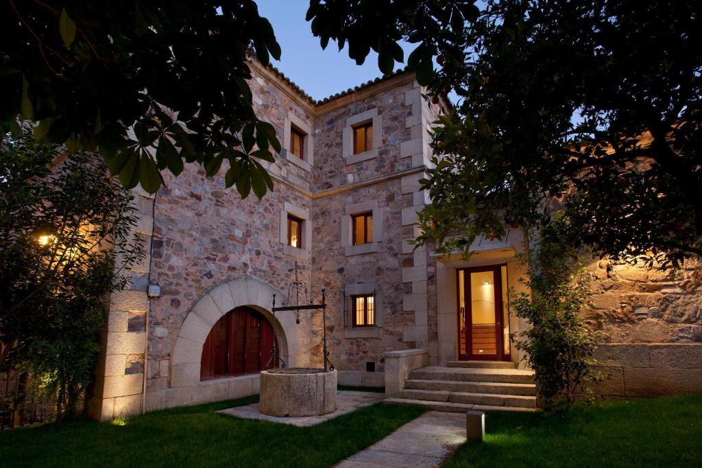 een groot stenen gebouw met een deur en een trap bij Parador de Caceres in Cáceres