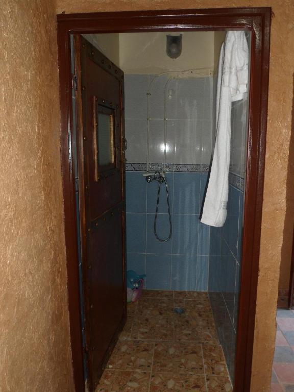 a bathroom with a shower with blue tiles at Tarmguist in Tighmert