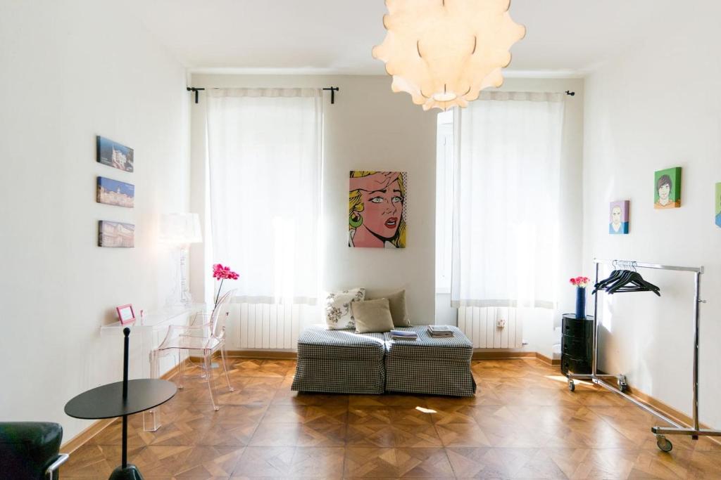 a living room with a couch and a chandelier at Alla Scalinata del Teatro Rossetti in Trieste