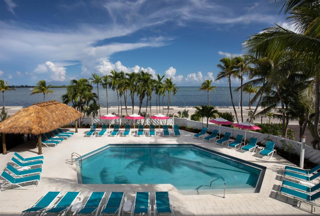 a swimming pool with lounge chairs and a beach at The Laureate Key West in Key West