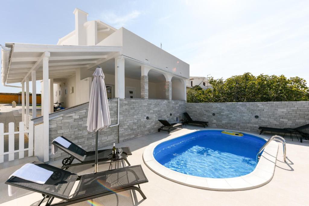 a swimming pool in the backyard of a house at Diva Apartment in Povljana