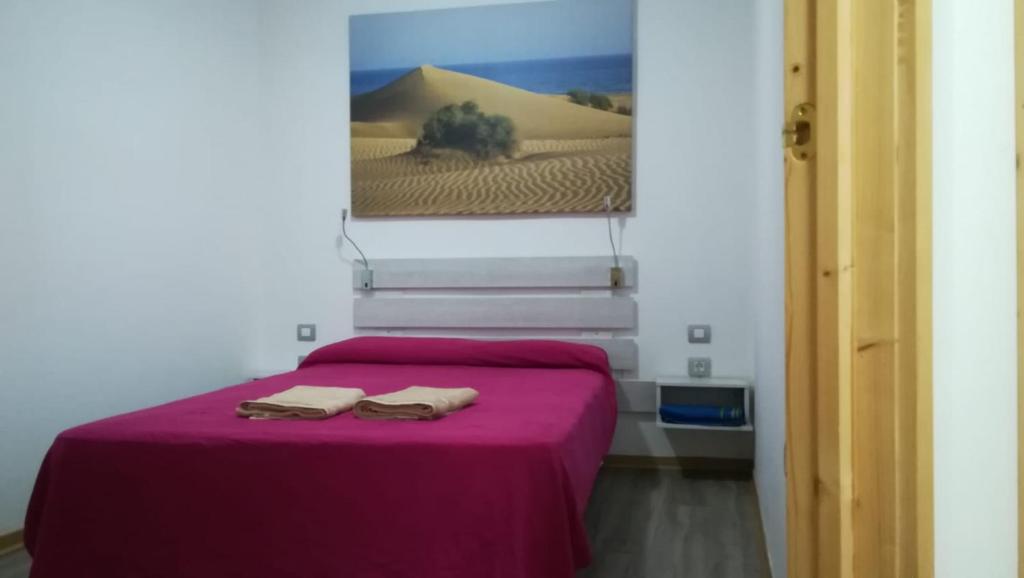 アリナガにあるApartamento la piedra viva 2 arinagaのベッドルーム1室(紫色のベッド1台、タオル2枚付)