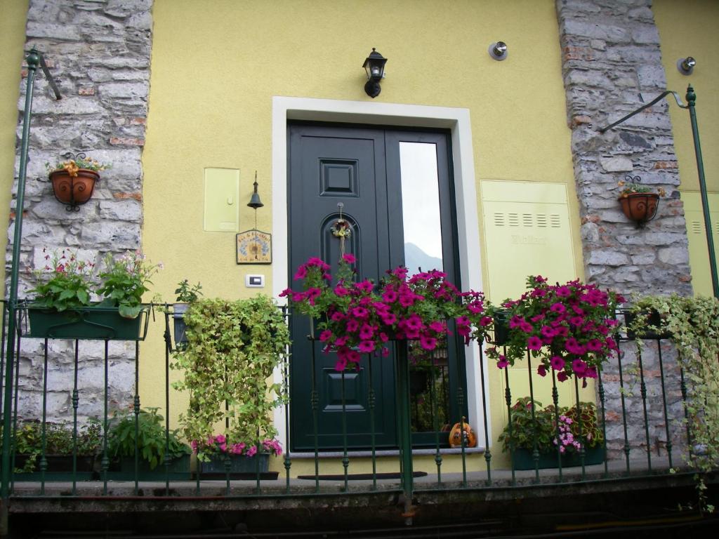 a black door with flowers on a fence at B&B La Cà De La Frà in Gravedona