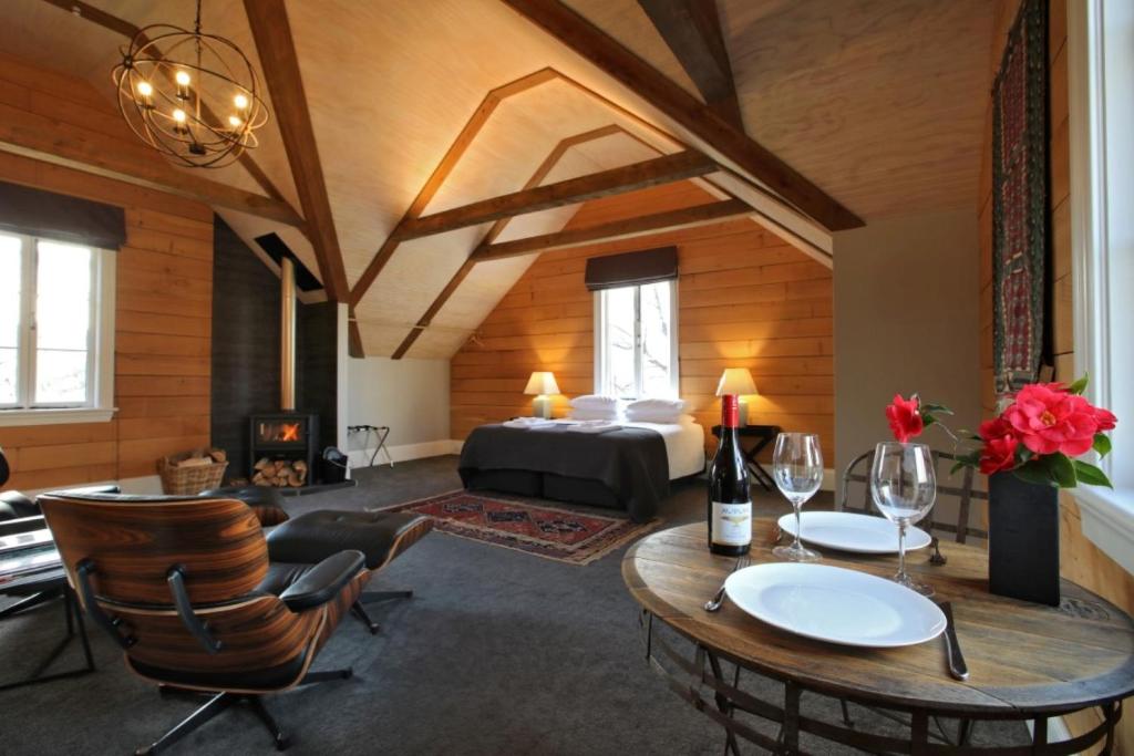 a room with a bed and a table and chairs at O Naturel Vineyard Stay in Cromwell