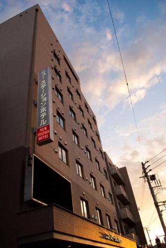 Un edificio alto con un cartel al costado. en New Station Hotel, en Isahaya