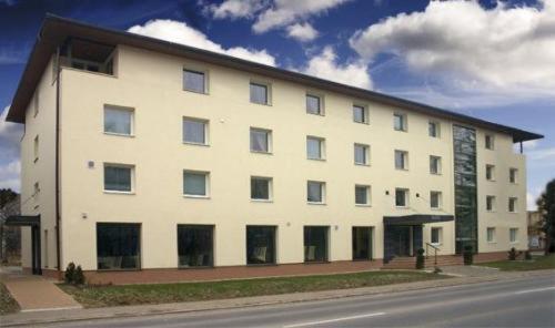 un gran edificio blanco al lado de una calle en Hotel Galileo, en Žilina