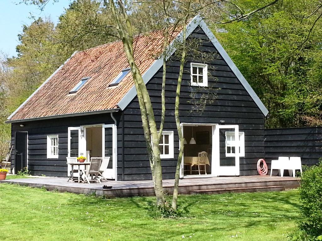 een zwart huis met een veranda en een patio bij Gastenverblijf Oostdijk in Goedereede