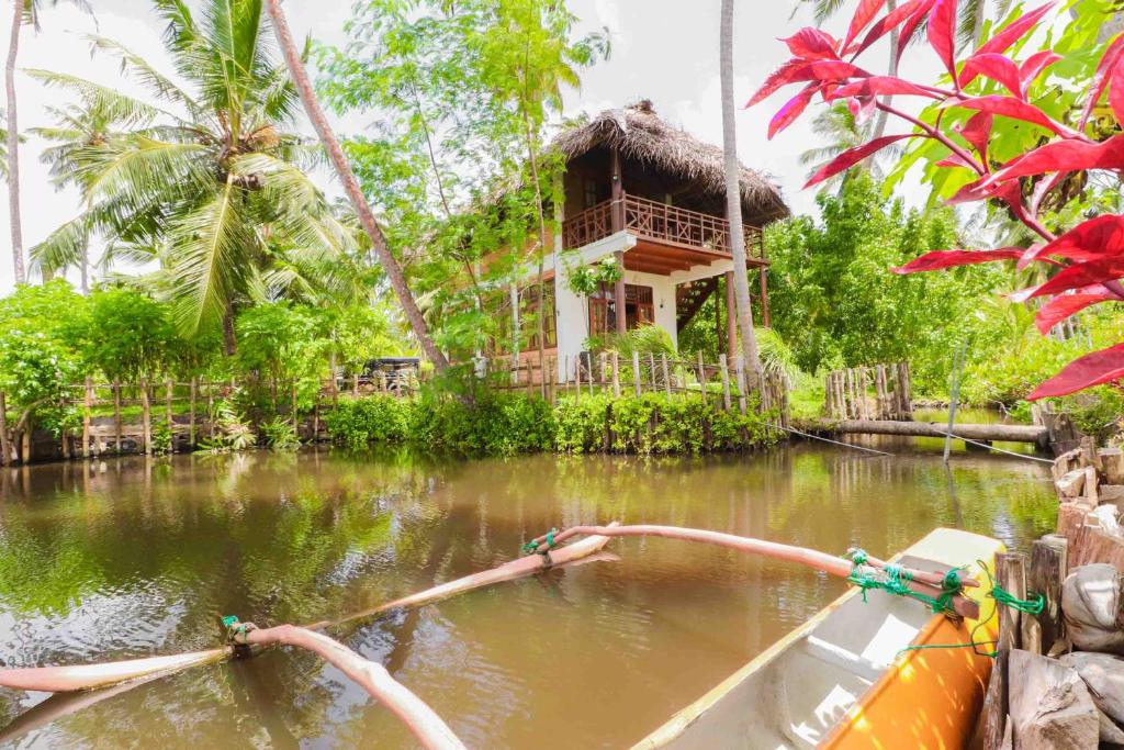 Milkyway Holiday Resort في يوناواتونا: قارب في الماء امام المنزل