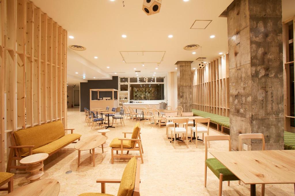 a restaurant with wooden tables and chairs and tables and benches at YUMORI ONSEN HOSTEL in Fukushima