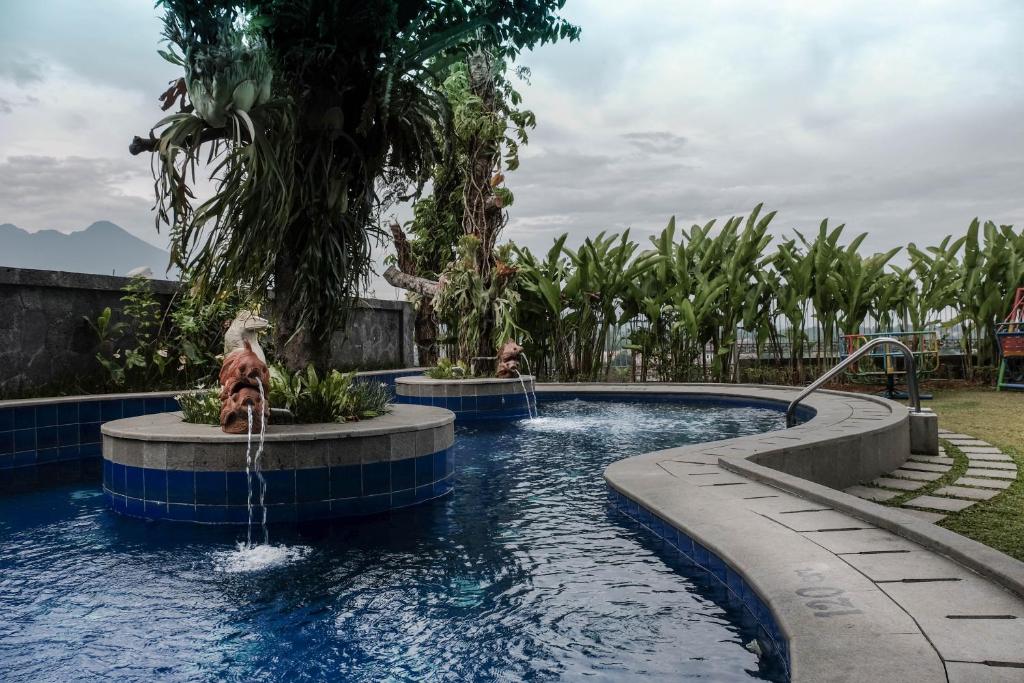 a swimming pool with two fountains in a resort at Onih Hotel in Bogor