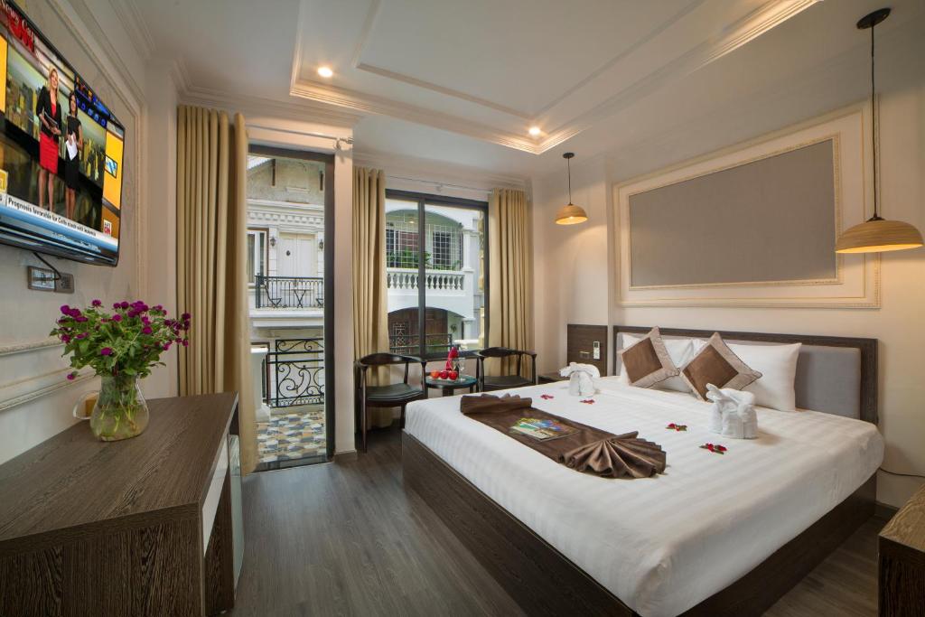 ein Schlafzimmer mit einem großen weißen Bett in einem Zimmer in der Unterkunft Galliot Central Hotel in Hanoi