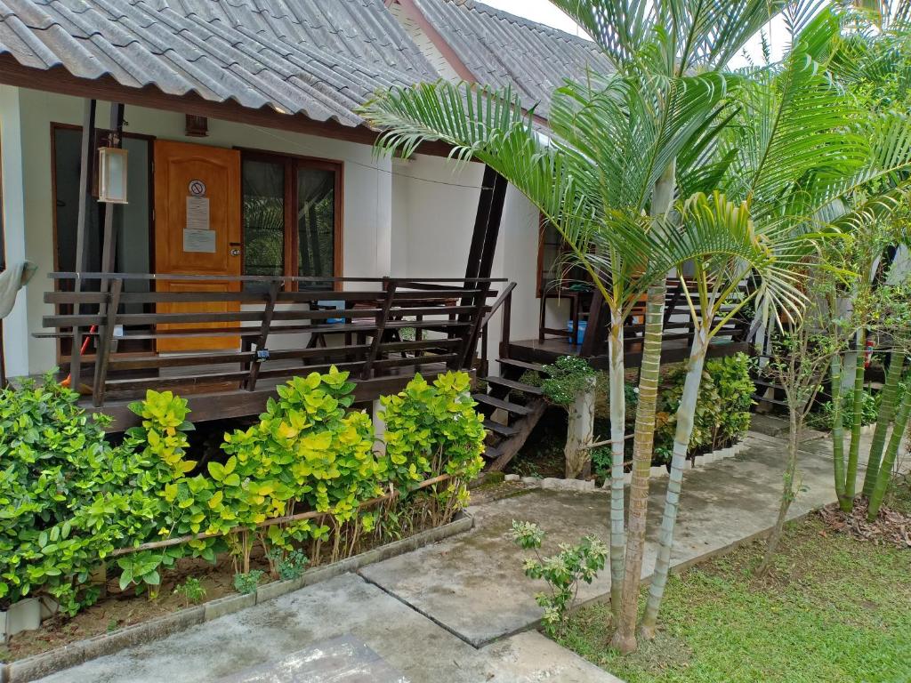 a house with a bench and a palm tree at paibaansuan in Pai