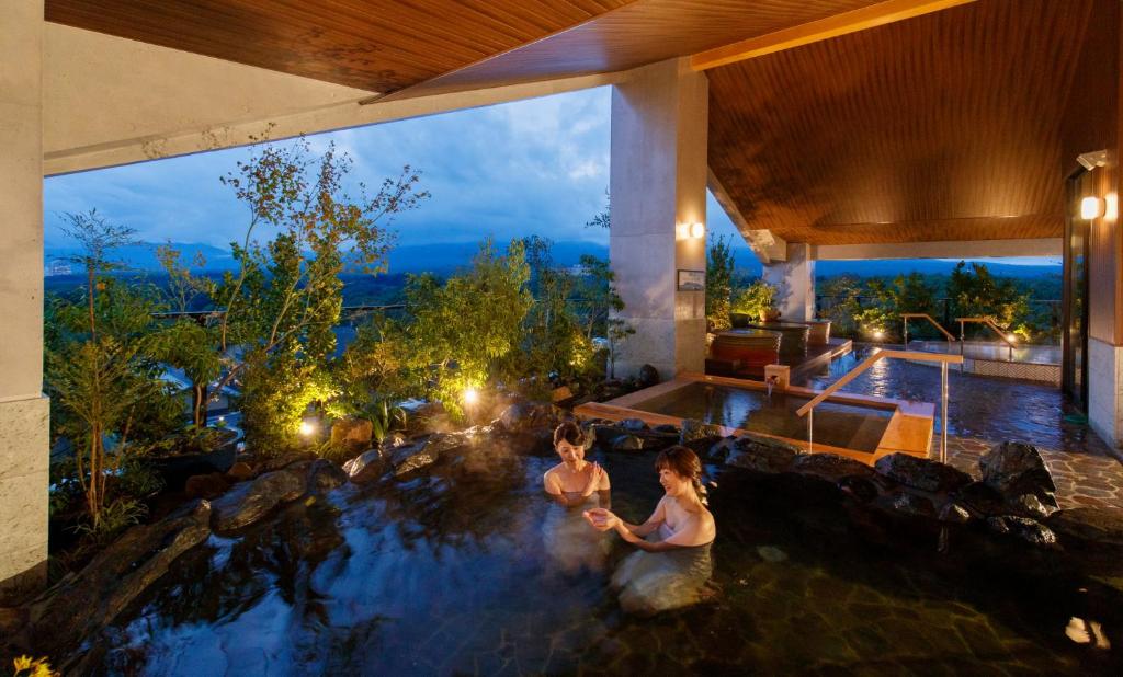 due donne che fanno il bagno in una piscina in una casa di Hotel Mori no Kaze Nasu a Nasu