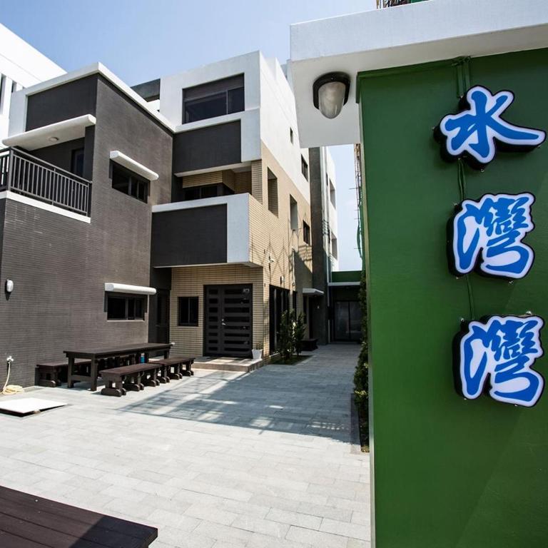 a building with blue signs on the side of it at Hsu One One B&B in Magong