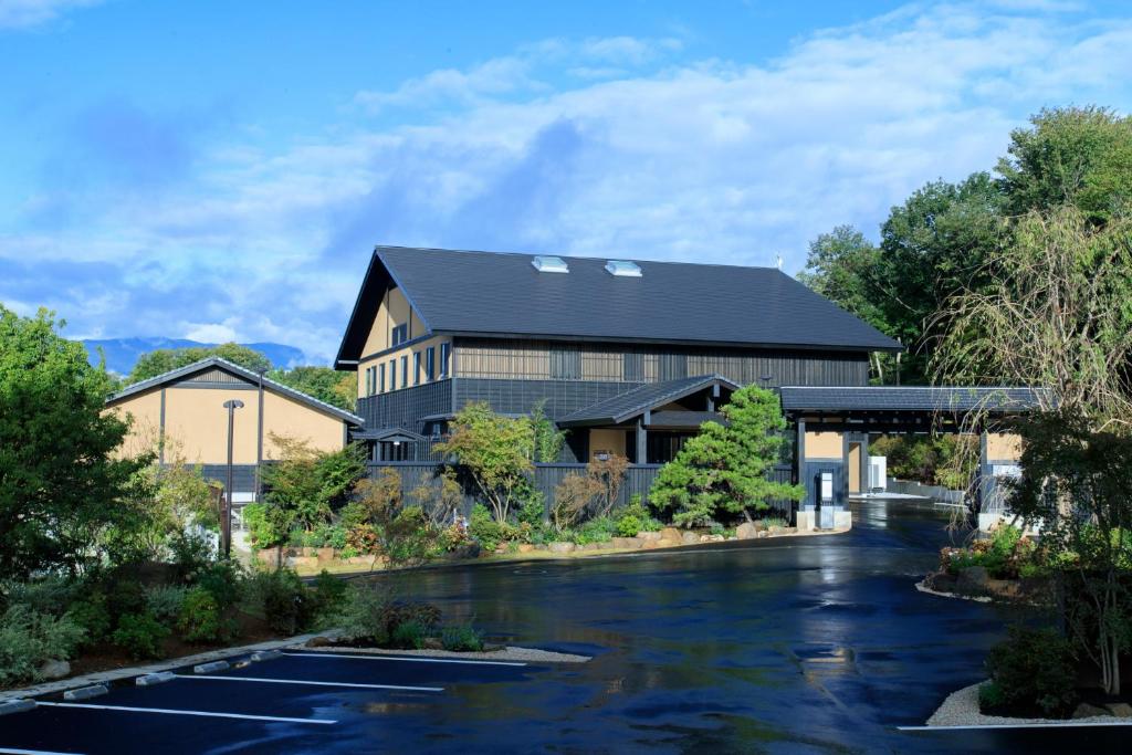 un bâtiment avec une rivière devant lui dans l'établissement Hotel Shiki no Yakata Nasu, à Nasu