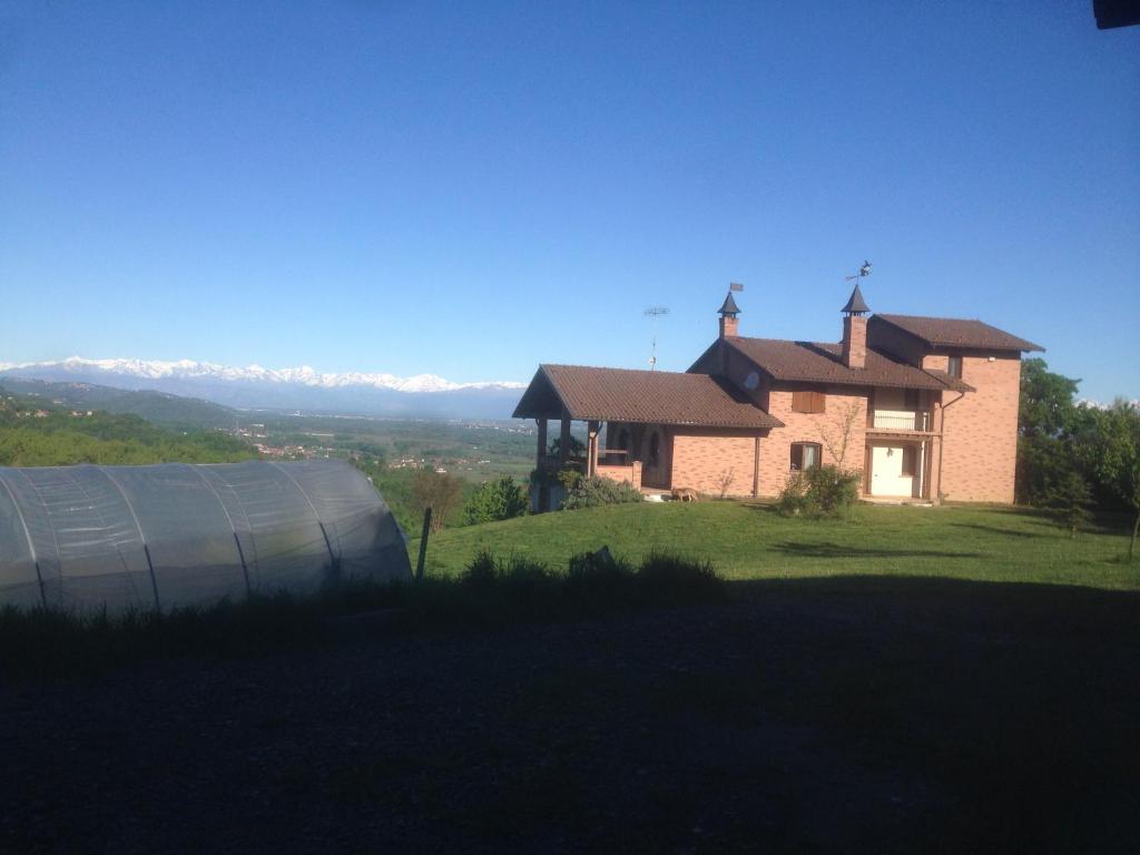 een huis bovenop een grasheuvel met een gebouw bij La Streghina Paolina in Verrua Savoia