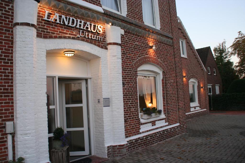 um edifício de tijolos com um sinal para uma clínica de antiguidades em Hotel Garni Landhaus Uttum em Greetsiel