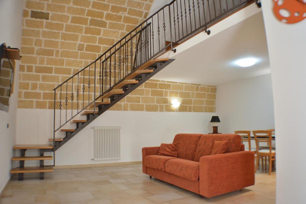 sala de estar con escalera y silla en Borgo Saraceno, en Spinazzola