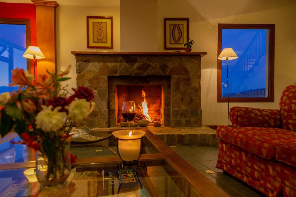 sala de estar con chimenea y sofá en Terraza Coirones Hotel en El Calafate