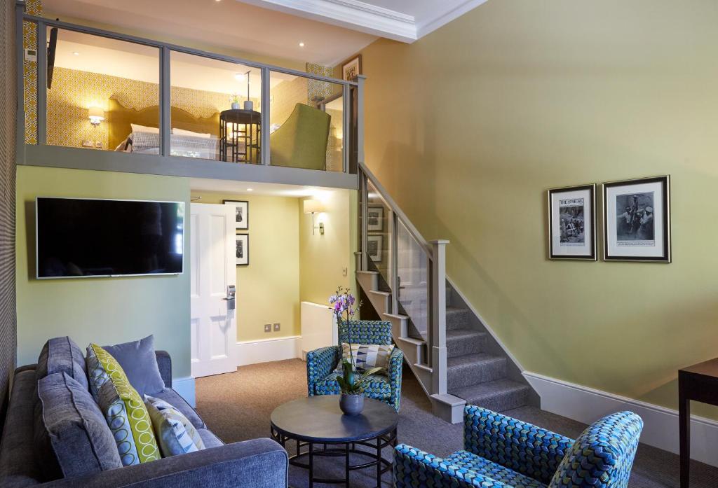 a living room with a couch and a staircase at 54 Queen's Gate Hotel in London