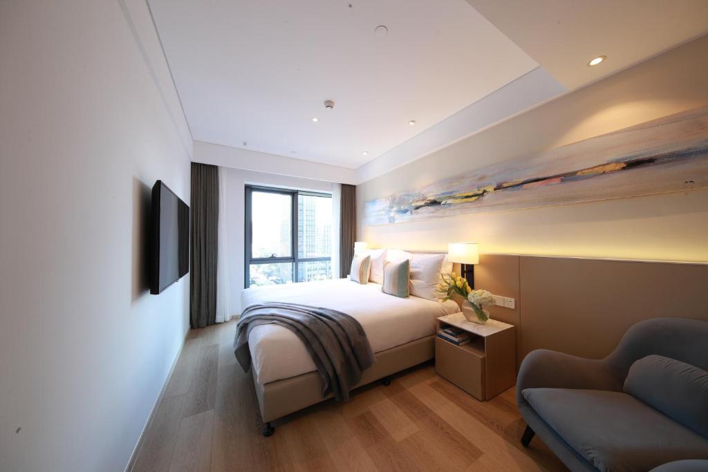 a hotel room with a bed and a couch at Sincere Residence Changfeng - Changfeng Ecological Business District - Near Exit 3 of Changfeng Park Station on Subway Line 15 in Shanghai