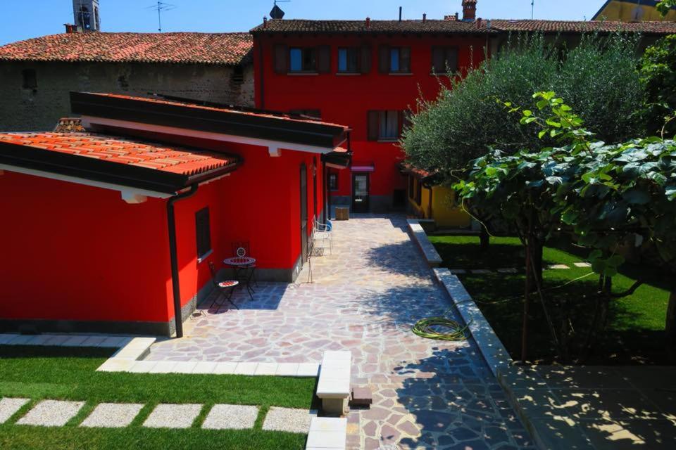 ein rotes Gebäude mit einem Weg davor in der Unterkunft CaMé in Alzano Lombardo