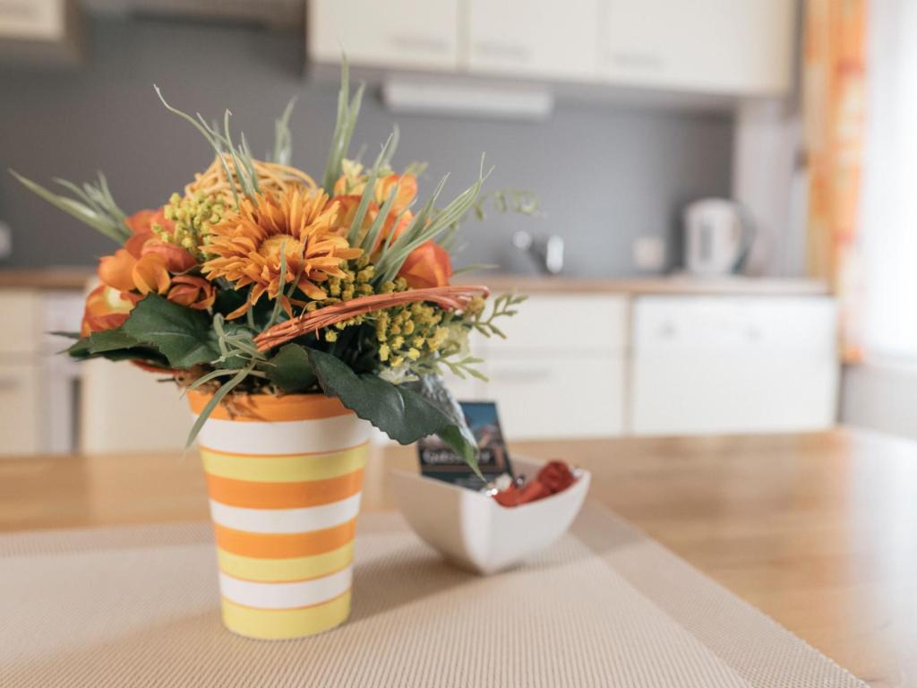 un jarrón con un ramo de flores sobre una mesa en Privatzimmer und Ferienwohnungen Gassner, en Admont