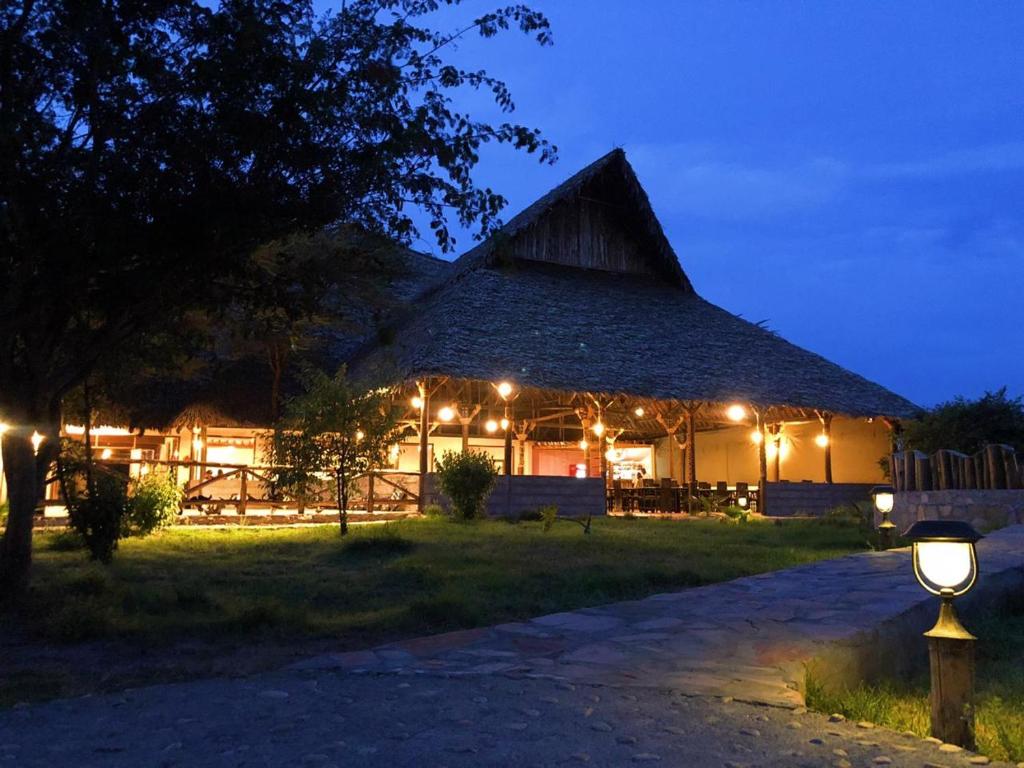 um celeiro iluminado à noite com luzes em Mara Sweet Acacia Lodge em Talek