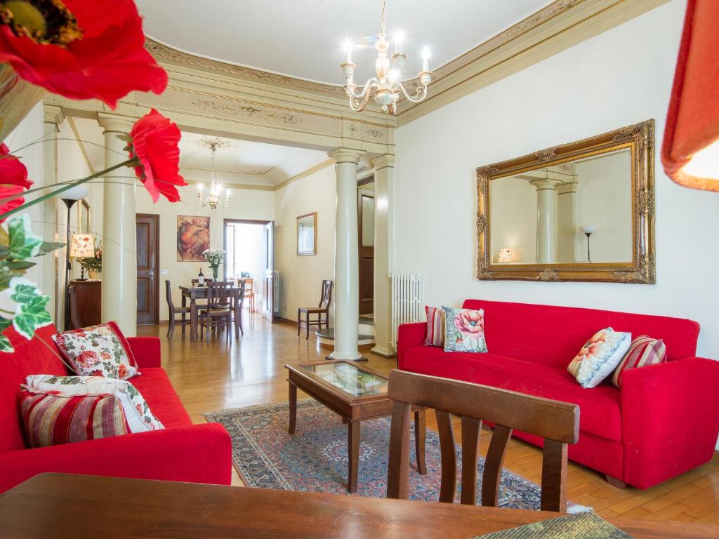 ein Wohnzimmer mit roten Sofas und einem Spiegel in der Unterkunft Verdi in Florenz