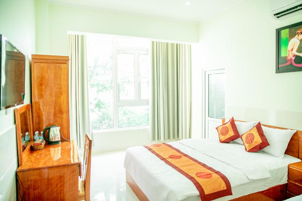 a hotel room with a bed and a window at Khách Sạn Anh Khoa in Phan Rang