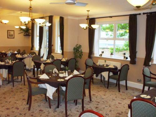 a dining room with tables and chairs in a restaurant at Lauriston Hotel in Weston-super-Mare