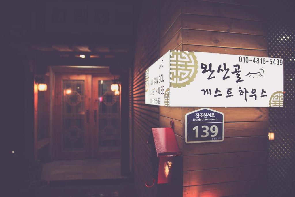 ein Schild an der Seite eines Gebäudes mit Schreiben in der Unterkunft Wansangolgh Guest House in Jeonju