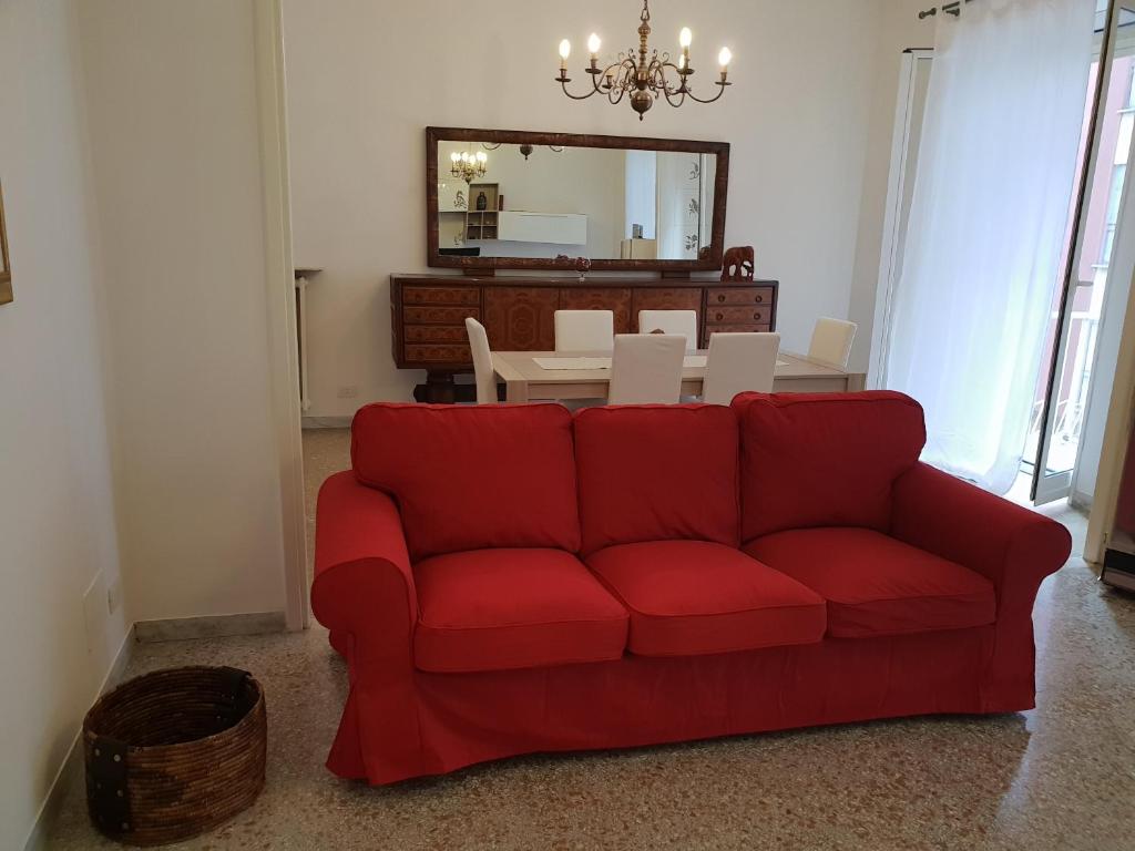 a red couch in a living room with a table at Casa Vacanza Venturi in Rome