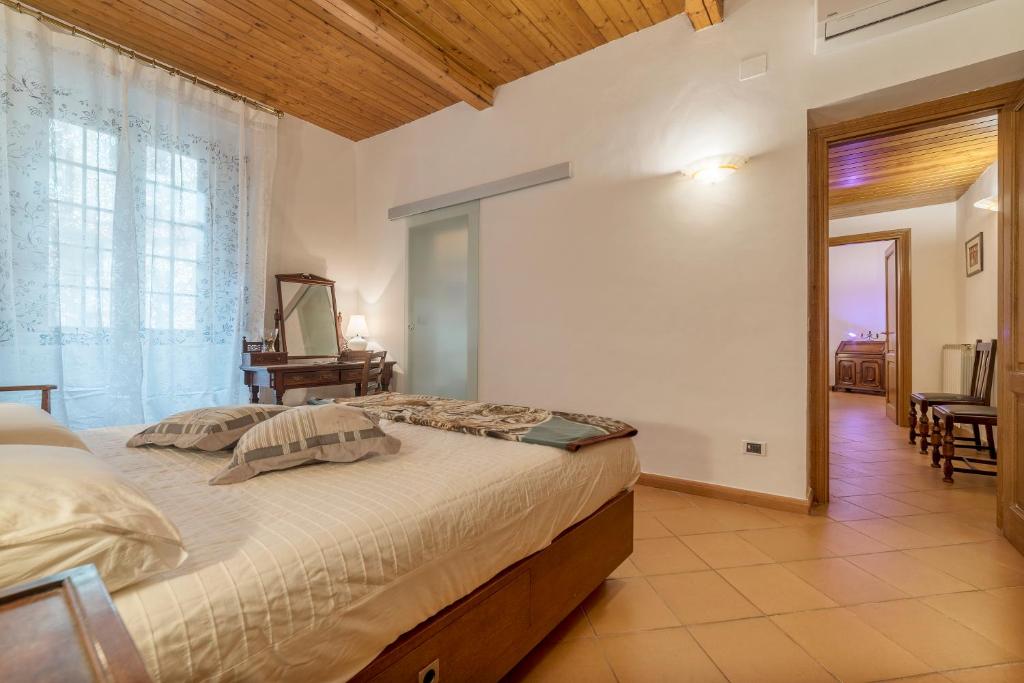 sypialnia z dużym łóżkiem i dużym oknem w obiekcie Villa Borghese Roomy Flat w Rzymie