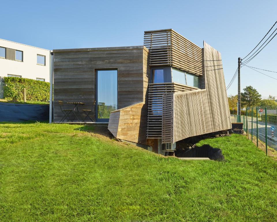 une petite maison sur une colline avec une pelouse dans l'établissement La Huche, à Namur