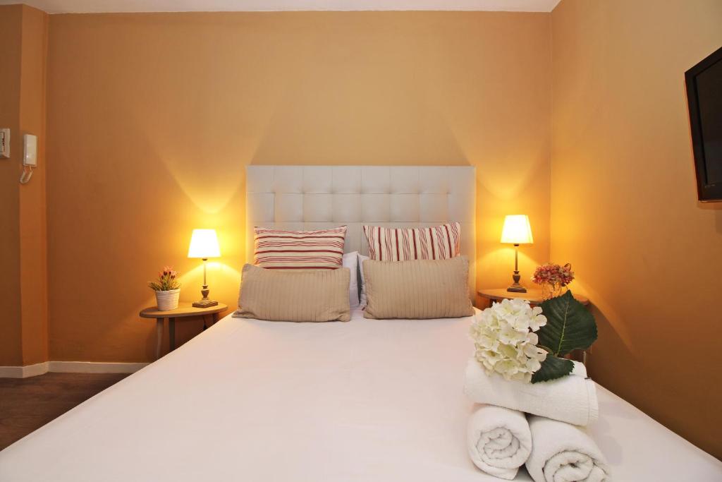 マラガにあるDel Parque Flats Suite Malaguetaのベッドルーム1室(白い大型ベッド1台、タオル付)