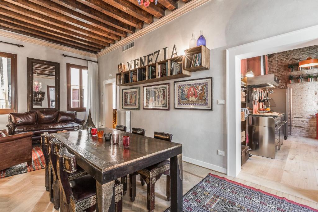 uma sala de estar com uma mesa e um sofá em Ca' Via della Seta em Veneza