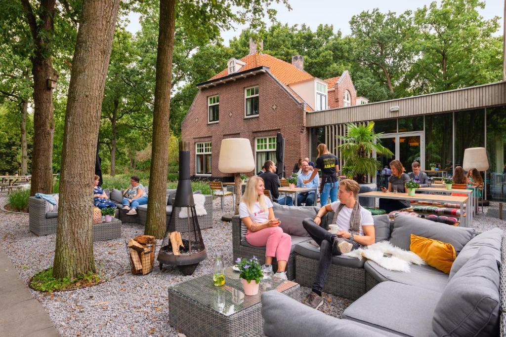 een groep mensen op banken in een tuin bij Stayokay Hostel Soest in Soest