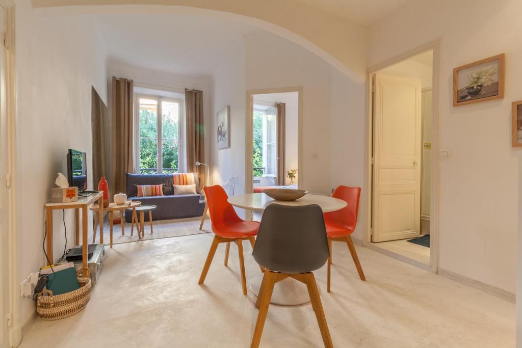 sala de estar con mesa y sillas de color naranja en Cannes Conseil Immo, Pedestrian Street Modern & quiet -Bai-, en Cannes