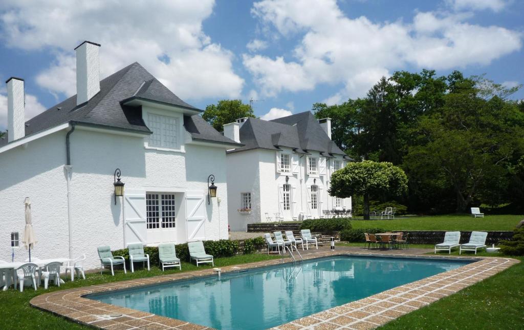 un edificio con piscina di fronte a un edificio di Clos Mirabel Manor - Holiday rental a Jurançon