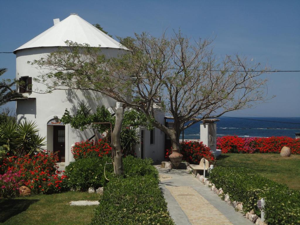 a white house with a tree and flowers at Villa Mantalena in Skiros