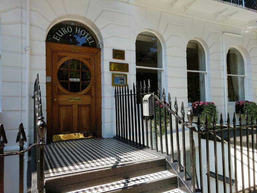 uma entrada para um edifício com uma porta de madeira em Euro Hotel em Londres