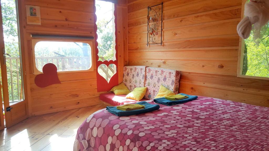 1 dormitorio con 1 cama en una habitación de madera en Cabanes Sainte Camelle en Saint-Victor-Rouzaud