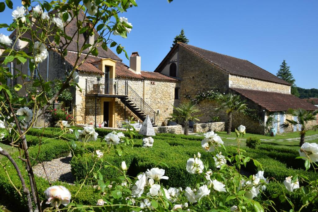 una casa con flores blancas delante de ella en L'Intemporelle B&B, en Le Buisson de Cadouin