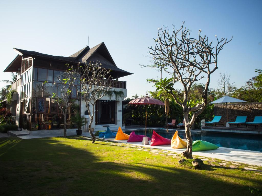 a house with a yard with colorful pillows next to a pool at Casa Ola Villa Pererenan in Canggu